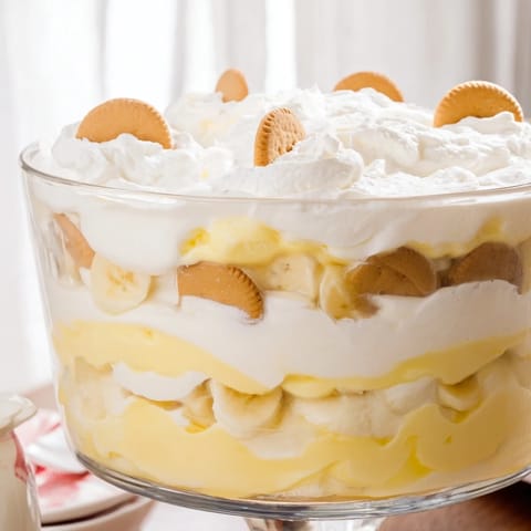 Creamy Southern Banana Pudding layered with vanilla wafers and fresh banana slices, topped with whipped cream.