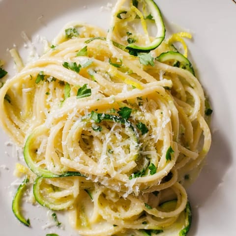 Bright and zesty Lemon Zucchini Pasta with spiralized zucchini ribbons in a glossy lemon butter sauce, garnished with fresh parsley and grated Parmesan.  