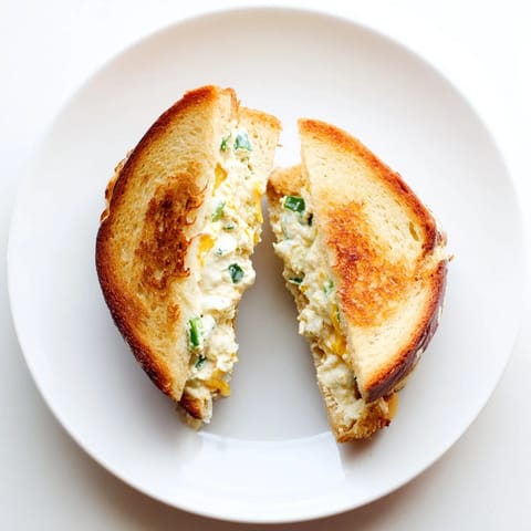 Golden-brown sourdough grilled cheese sandwiches stuffed with a creamy blend of cream cheese, sharp cheddar, and fresh, chopped jalapeños.  