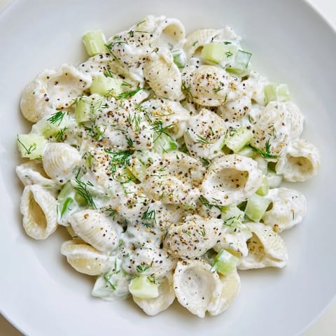 Cool, creamy Cucumber Crunch Pasta Salad with tender shells, fresh dill, and everything bagel seasoning on a picnic table.