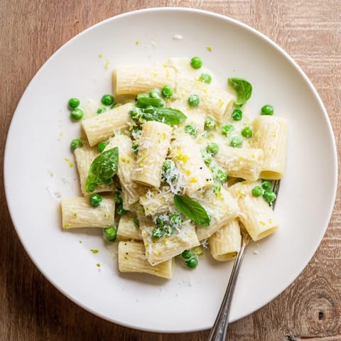 Bright green peas and creamy ricotta sauce coat al dente rigatoni in this Pea & Lemon Ricotta Pasta, topped with lemon zest.