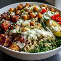 A vibrant Mediterranean Buddha Bowl Meal Prep features golden roasted eggplant, steamed kale, and creamy tahini dressing for a healthy lunch.