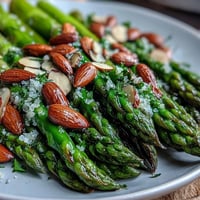 Fresh asparagus spears glistening in lemon butter, topped with golden toasted almonds for a crisp, nutty bite.