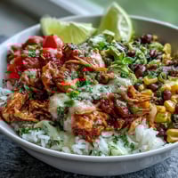 Flavorful salsa chicken bowls with shredded chicken in zesty tomato salsa, served over rice with fresh toppings and avocado slices.  